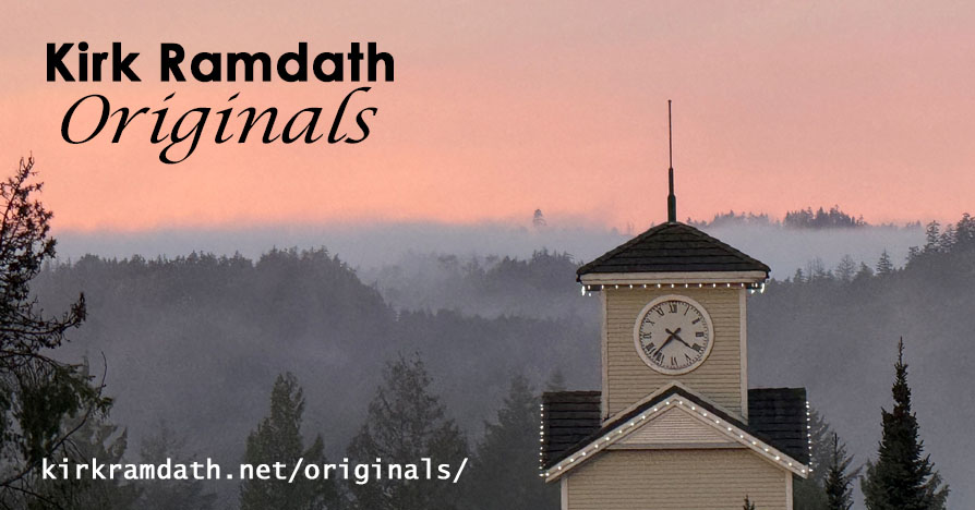 Image shows a clock tower in the foreground and a forested, foggy background with an orange sky.